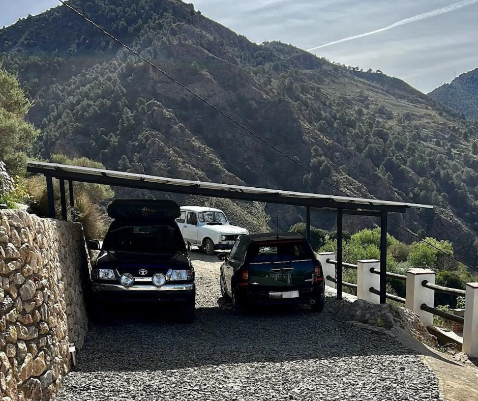 pergola con paneles solares generando energía para dos coches en día soleado