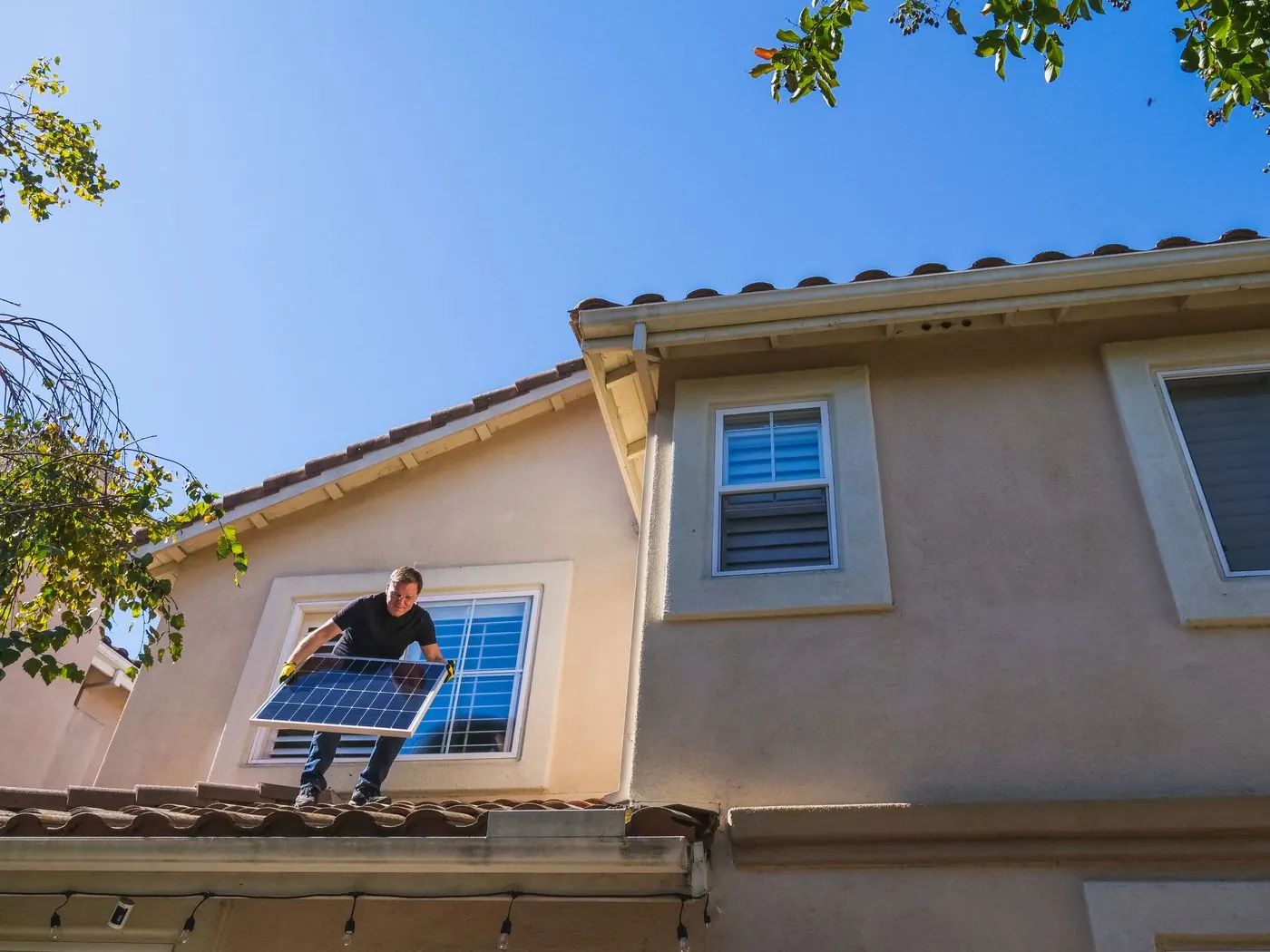 Instalador colocando un panel solar en el tejado de una vivienda