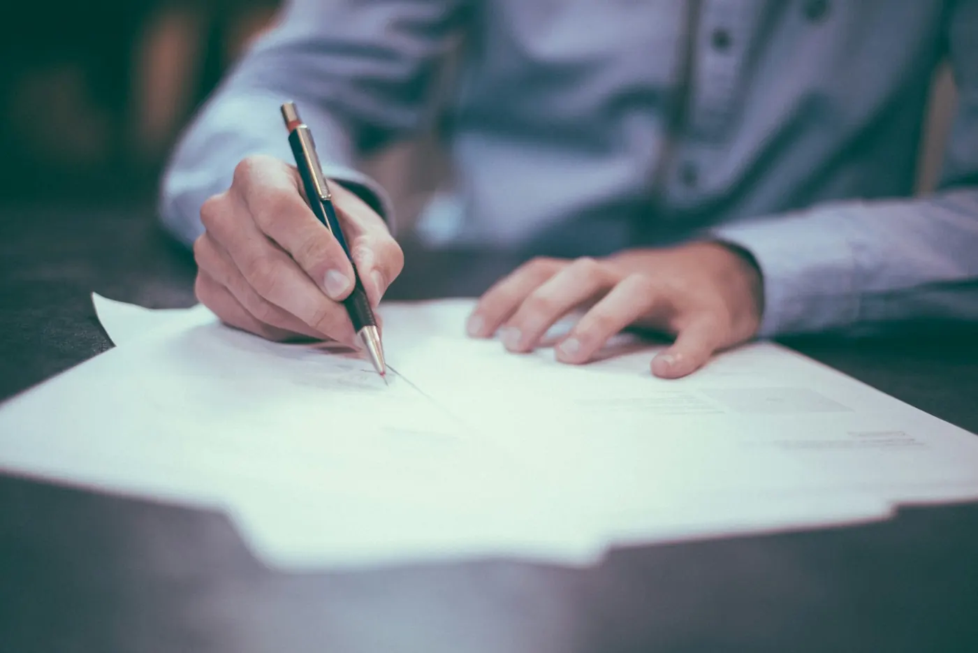 Hands reviewing contracts and documents at a desk