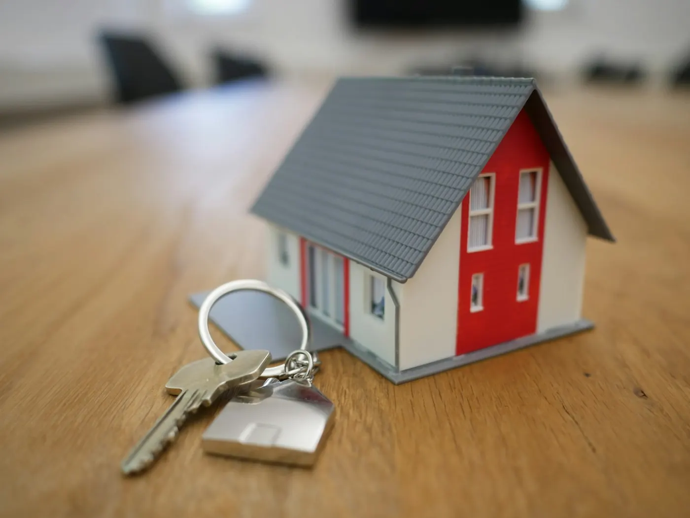 House keys beside a miniature home model